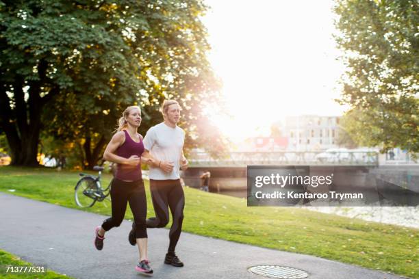 couple jogging on footpath at park during sunrise - runner sunrise stock pictures, royalty-free photos & images