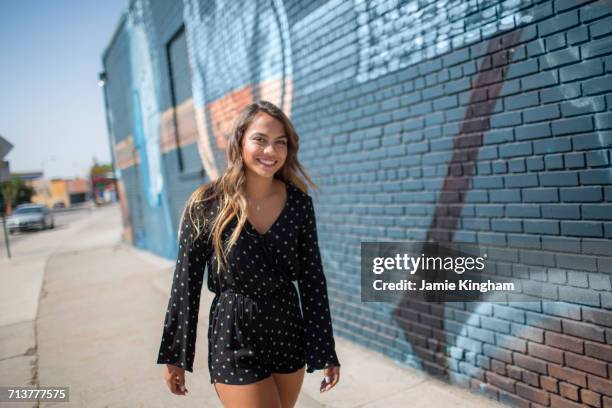 portrait of teenage girl in stylish playsuit strolling on sidewalk - nevada city stock pictures, royalty-free photos & images