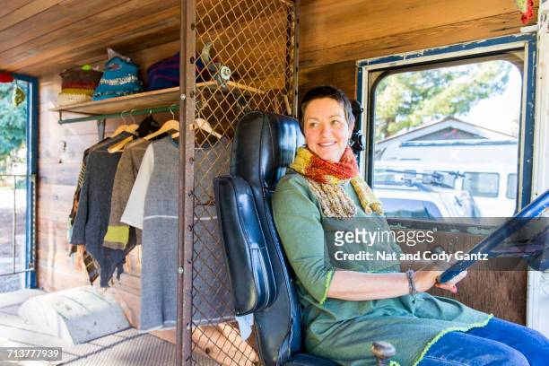 Mature hippy woman in driving seat of camper van
