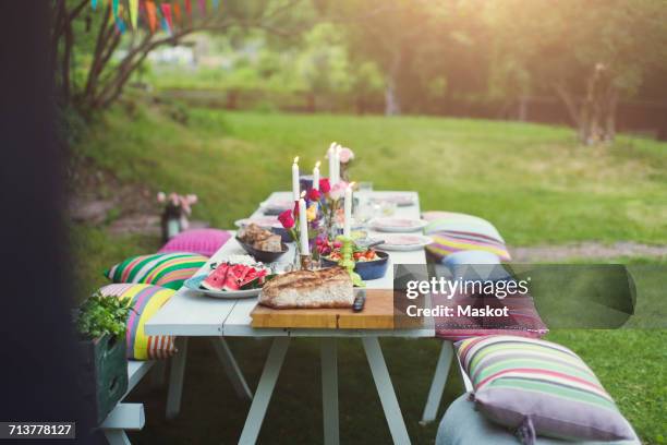 food served on decorated picnic table at back yard during garden party - empty picnic table stock pictures, royalty-free photos & images