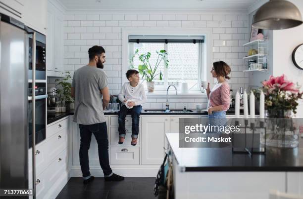 father and mother with son in kitchen at home - famiglia cucina foto e immagini stock