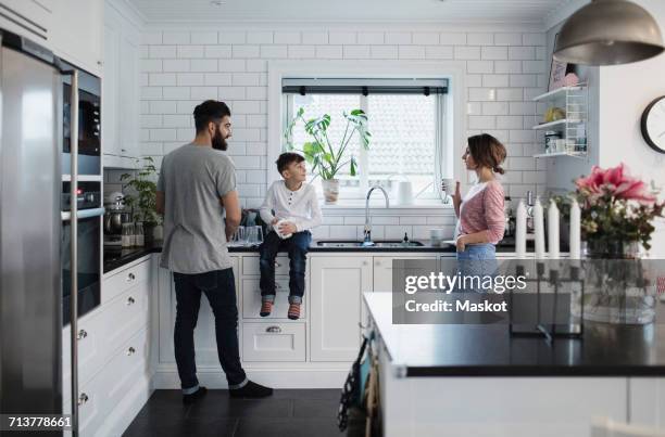 father and mother with son in kitchen at home - family at kitchen stockfoto's en -beelden