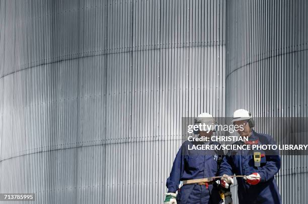 engineers by oil storage tower - raffinaderij stockfoto's en -beelden