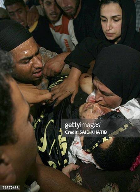 Palestinian relatives of Mohammed Abu Taer bid farewel as his body is taken for burial from his home in the Abassan area in Khan Yunis the southern...