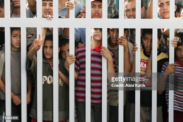 Palestinian bystanders look through the gate of Odwan hospital where a wounded man was brought during clashes with Israeli troops July 6, 2006 in...