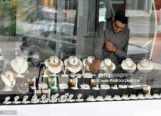 Pakistani shopkeeper arranges jewellery in the window of a jewellery shop in Islamabad, 07 July 2006. Gold prices on the Hong Kong market closed...