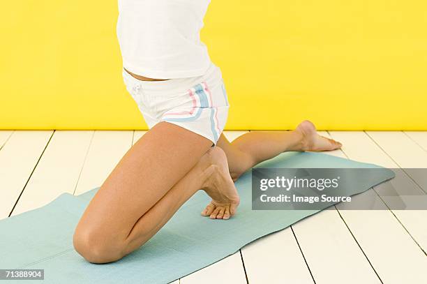 woman kneeling on yoga mat - one woman only kneeling stock pictures, royalty-free photos & images