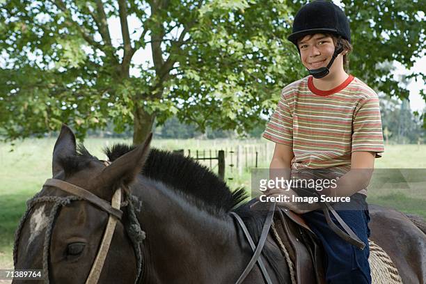 馬に乗る少年 - 乗馬帽 ストックフォトと画像