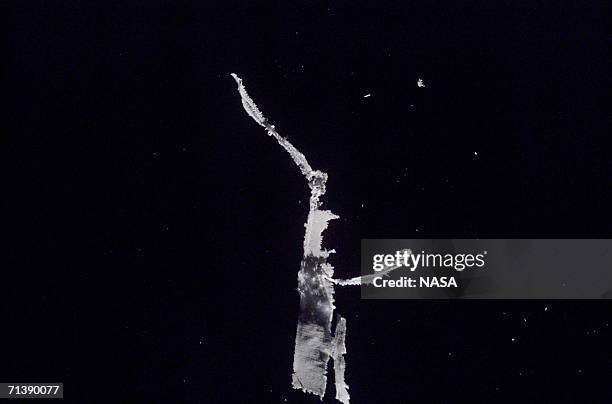 In this handout photo provided by NASA, ice, believed to have come from the orbiter's main engine nozzles, floats freely several yards from shuttle...
