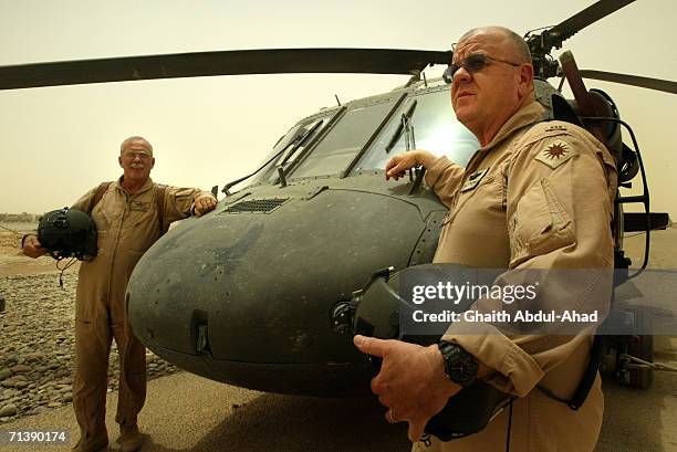 Army pilots CW5 DeWayne Browning and CW3 Randy Weatherhead veterans of the Vietnam war stand next to their Black Hawk helicopter in the airfield on...