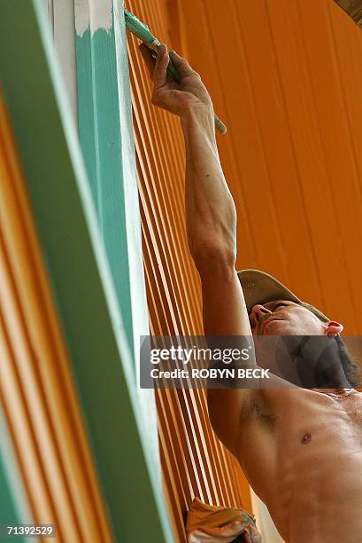 New Orleans, UNITED STATES: Brian Stoken of Grand Rapids, Michigan, paints a historic open market building during restoration to be used as a...