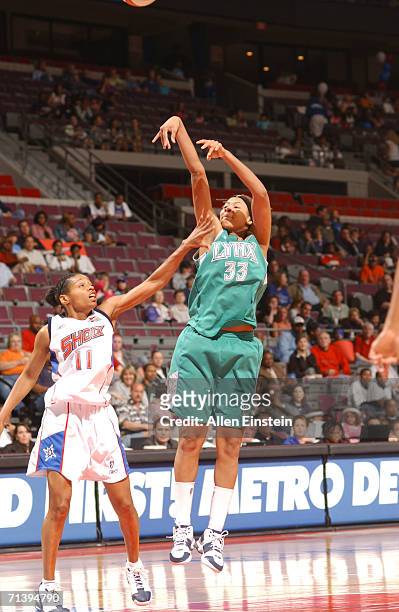 Seimone Augustus of the Minnesota Lynx shoots over Kedra Holland-Corn of the Detroit Shock during the game at the Palace of Auburn Hills in Detroit,...