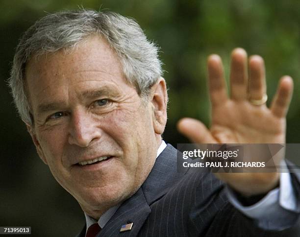 Washington, UNITED STATES: US President George W. Bush waves from the South Lawn of the White House 07 July 2006 as he returns from an overnight trip...