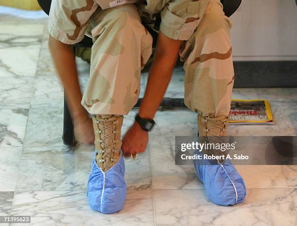 Army nurse slides scrub covers over her boots June 16, 2006 at the 10th CaSH in Baghdad, Iraq. The 10th CaSH occupies the Ibn Sina Hospital, touted...