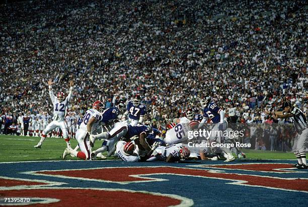 Jim Kelly of the Buffalo Bills signals for a touchdown as running back Don Smith tries to break through to the end zone somewhere under the New York...