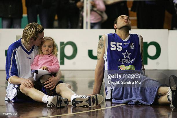 Josh Nigut of Auckland hangs his head back while team mate Dillon Boucher comforts his daughter after they lost the NBL final between the Auckland...