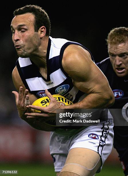 Brad Ottens of the Catsmarks in front of Lance Whitnall of the Blues during the round 14 AFL match between the Carlton Blues and Geelong Cats at...