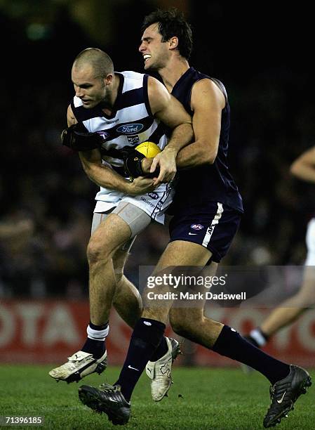 Tom Harley of the Cats marks despite the efforts of Adrian Deluca of the Blues during the round 14 AFL match between the Carlton Blues and Geelong...