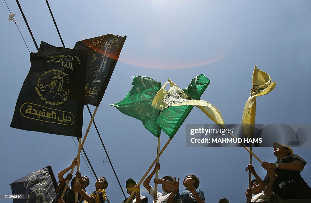 Palestinian boys hold up flags from the