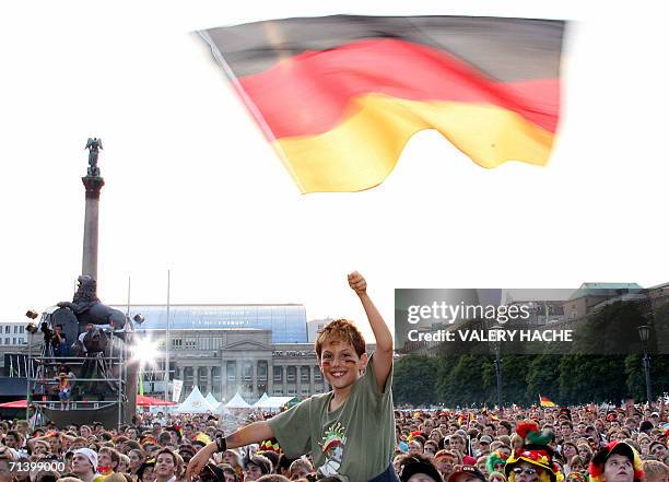 Young Germany supporter waves the country's flag as fans gather in downtown Stuttgart before the third-place playoff 2006 World Cup football match...