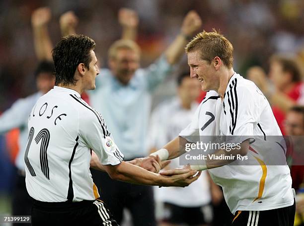 Bastian Schweinsteiger of Germany is congratulated by his team mate Miroslav Klose after opening the scoring during the FIFA World Cup Germany 2006...