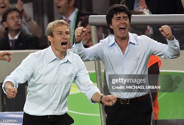 German head coach Juergen Klinsmann and German assistant coach Joachim Loew celebrates after German midfielder Bastian Schweinsteiger scored the...