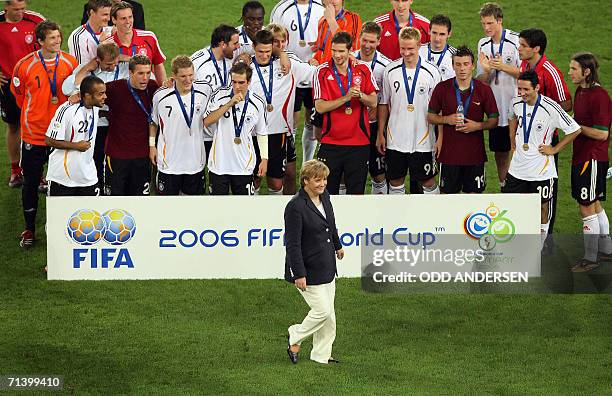 German Chancellor Angela Merkel walks in front of the German team following the medal presentation at the end of the third-place playoff 2006 World...