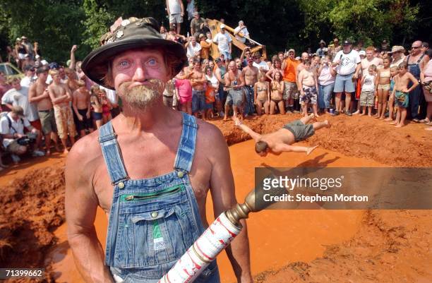 Bow, the official mascot of the Summer Redneck Games, poses next to the mud pit with the ceremonial torch during the 11th annual games July 8, 2006...