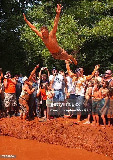 Winner of the Redneck Mud Pit Belly Flop contest, Andrew Fremming of Oviedo, Florida, jumps off the shoulders of his friend Gene Williams to win the...