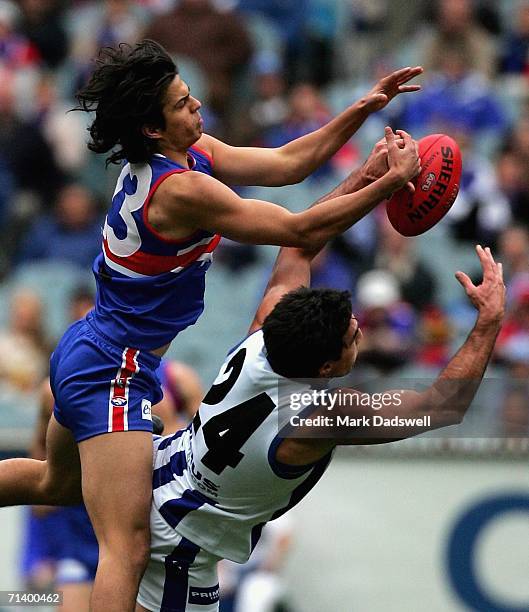 Jordan McMahon of the Bulldogs attempts to mark over Michael Firrito of the Kangaroos during the round fourteen AFL match between the Western...