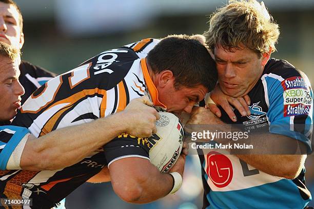 Chris Heighington of the Tigers is tackled by Brett Kimmorley of the Sharks during the round 18 NRL match between the Cronulla Sharks and Wests...