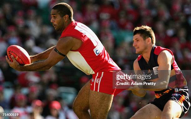 Michael O'Loughlin of the Swans has his shorts pulled by Nathan Bassett of the Crows during the round 14 AFL match between the Sydney Swans and the...