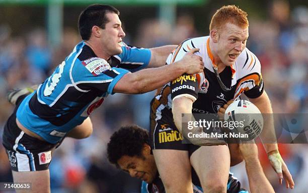 Paul Gallen of the Sharks cant stop Keith Galloway of the Tigers from offloading during the round 18 NRL match between the Cronulla Sharks and Wests...