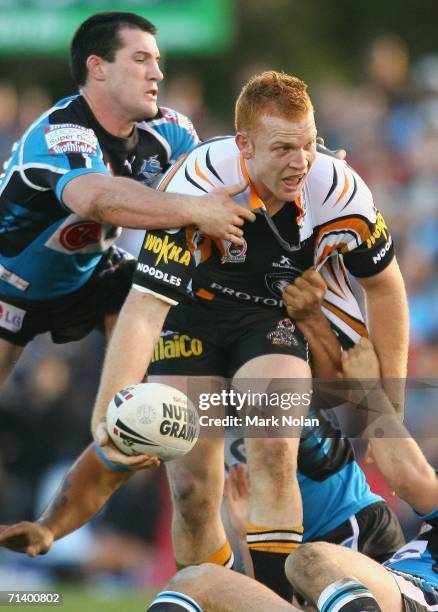 Paul Gallen of the Sharks cant stop Keith Galloway of the Tigers from offloading during the round 18 NRL match between the Cronulla Sharks and Wests...