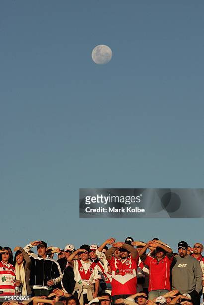 The moon rises behind the crowd as they watch the action during the round 18 NRL match between the St.George Illawarra Dragons and the South Sydney...