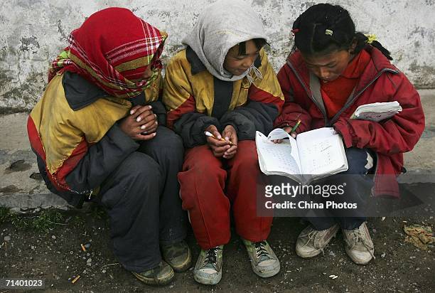 Tibetan students read book outside their classroom at the Wanquan Primary School at the Yanshiping Township on July 7, 2006 in Yanshiping Township,...