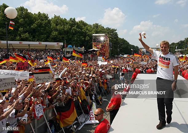 German head coach Juergen Klinsmann waves to supporters from the stage 09 July 2006 at the Fan Fest in Berlin. One million people took over central...