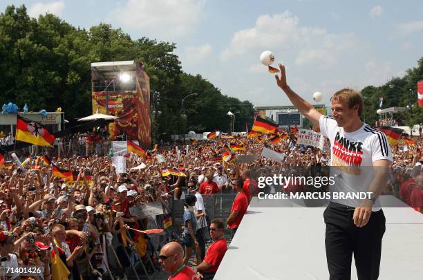 German head coach Juergen Klinsmann waves to supporters from the stage 09 July 2006 at the Fan Fest in Berlin. One million people took over central...