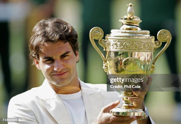 Roger Federer of Switzerland holds the trophy after winning the Men's final against Rafael Nadal of Spain on day thirteen of the Wimbledon Lawn...