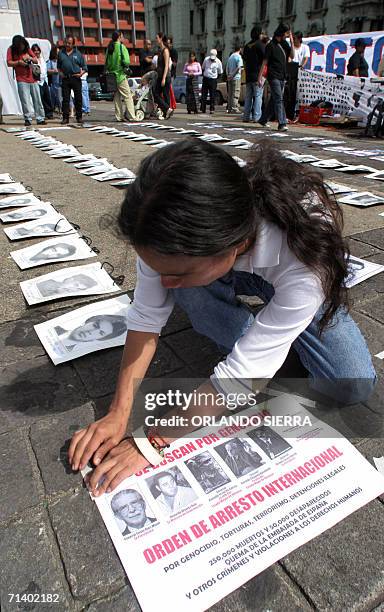 Un defensor de derechos humanos coloca afiches con fotografias de victimas del genocidio en Guatemala en la plaza de La Constitucion, frente al...
