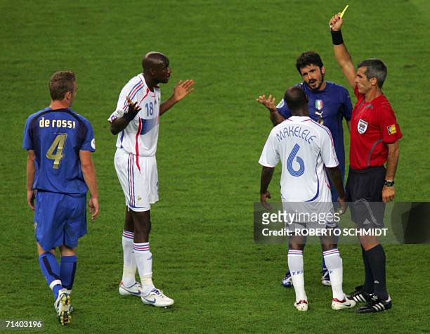 Argentine referee Horacio Elizondo shows a yellow card to French midfielder Alou Diarra as Italian midfielder Gennaro Gattuso and French midfielder...