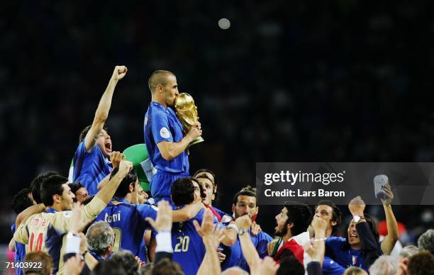 The Italian players celebrate as Fabio Cannavaro of Italy kisses the World Cup trophy following victory in a penalty shootout at the end of the FIFA...