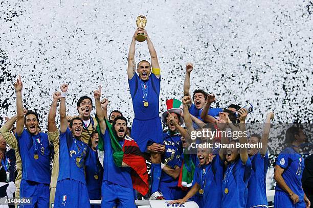 The Italian players celebrate as Fabio Cannavaro of Italy lifts the World Cup trophy aloft following victory in a penalty shootout at the end of the...