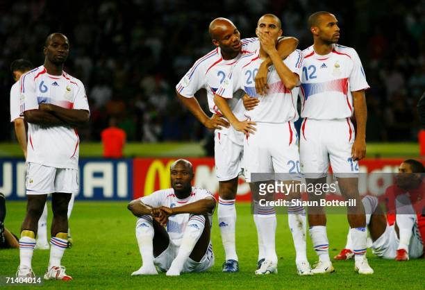 David Trezeguet of France is consoled by his team mates following his team's defeat in a penalty shootout at the end of the FIFA World Cup Germany...