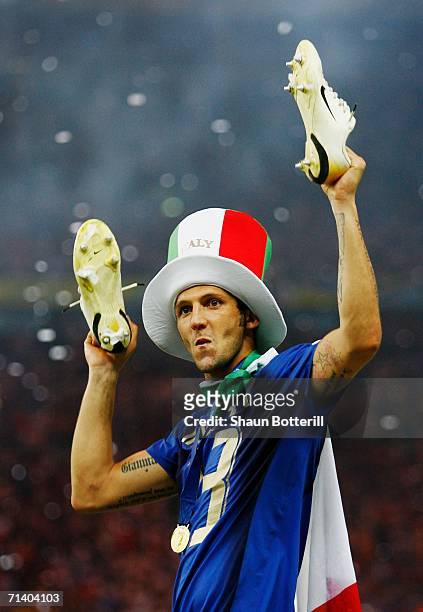 Marco Materazzi of Italy holds his boots aloft following his team's victory in a penalty shootout at the end of the FIFA World Cup Germany 2006 Final...