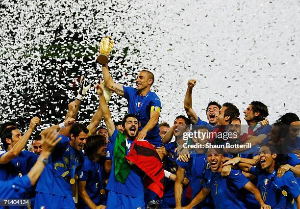 The Italian players celebrate as Fabio Cannavaro of Italy lifts the World Cup trophy aloft following victory in a penalty shootout at the end of the...