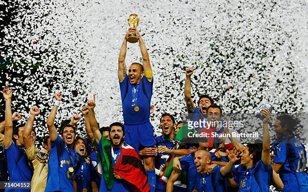 The Italian players celebrate as Fabio Cannavaro of Italy lifts the World Cup trophy aloft following victory in a penalty shootout at the end of the...