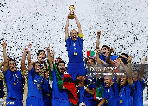 The Italian players celebrate as Fabio Cannavaro of Italy lifts the World Cup trophy aloft following victory in a penalty shootout at the end of the...
