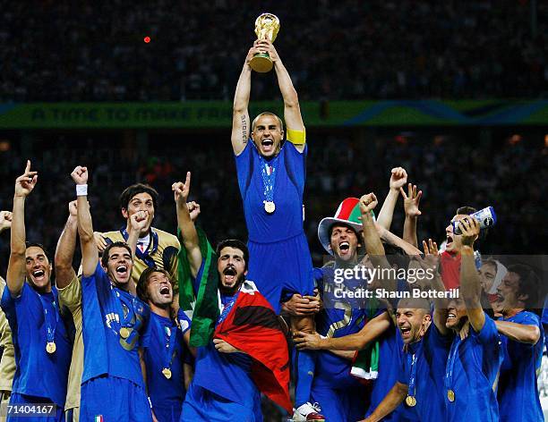 The Italian players celebrate as Fabio Cannavaro of Italy lifts the World Cup trophy aloft following victory in a penalty shootout at the end of the...