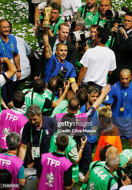 Fabio Cannavaro of Italy is surrounded by photographers as he lifts the World Cup trophy aloft following his team's victory in a penalty shootout at...